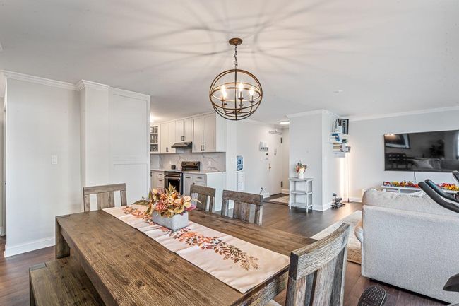 Dining space with a chandelier, dark wood-style floors, and ornamental molding | Image 14