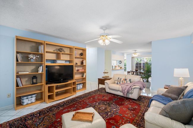 Living room featuring ceiling fan, baseboards, and light tile patterned floors | Image 9
