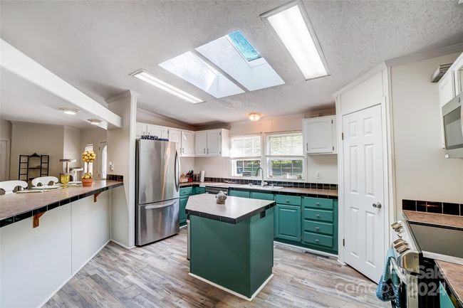 The well-appointed kitchen is a chef's delight, featuring skylights for natural illumination. | Image 12