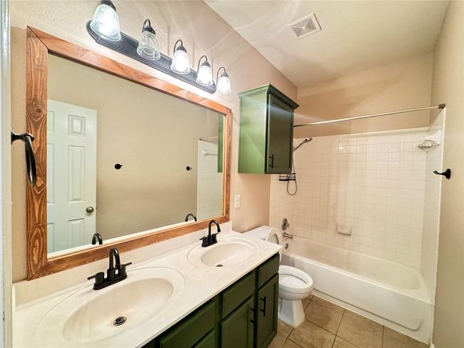 Full bath with tile patterned flooring, double vanity, and bathtub / shower combination | Image 18