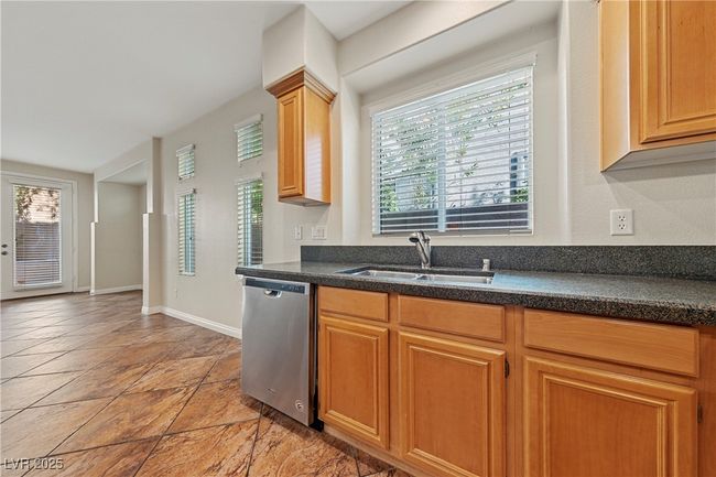 Kitchen featuring dishwasher, light stone finish floors, and dark stone countertops | Image 19