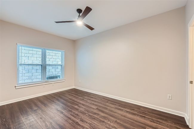 Spare room featuring dark wood finished floors and ceiling fan | Image 6