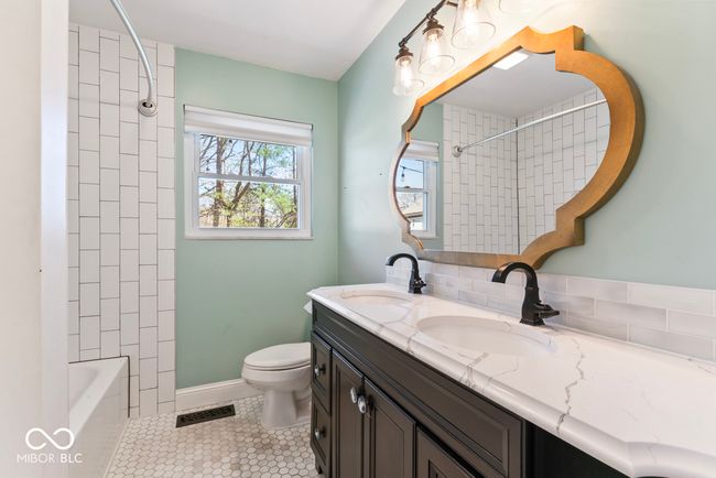 full bathroom featuring toilet, tile patterned floors, double vanity, and a sink | Image 24