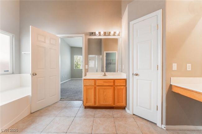 Full bathroom featuring vanity, a garden tub, tile patterned flooring, a stall shower, and baseboards | Image 31