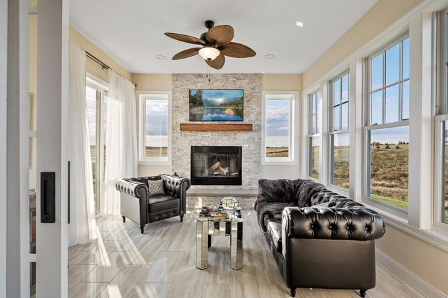 Just steps from the dining room, the sunroom boasts sliding barn doors and a second fireplace framed in stacked stone. | Image 9