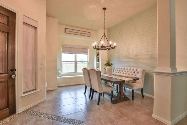 Dining room featuring an inviting chandelier, tile patterned flooring, and baseboards | Image 10