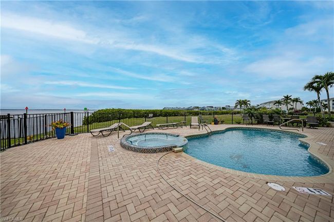 View of swimming pool featuring a patio area and a community hot tub | Image 42