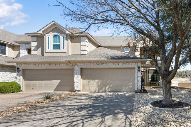 View of front facade with an attached garage, driveway, stone siding, roof with shingles, and stucco siding | Image 34