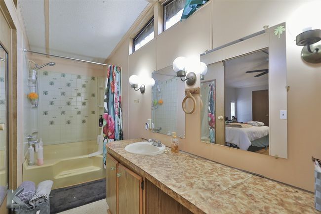 Bathroom featuring connected bathroom, shower / bath combo, and vanity | Image 28