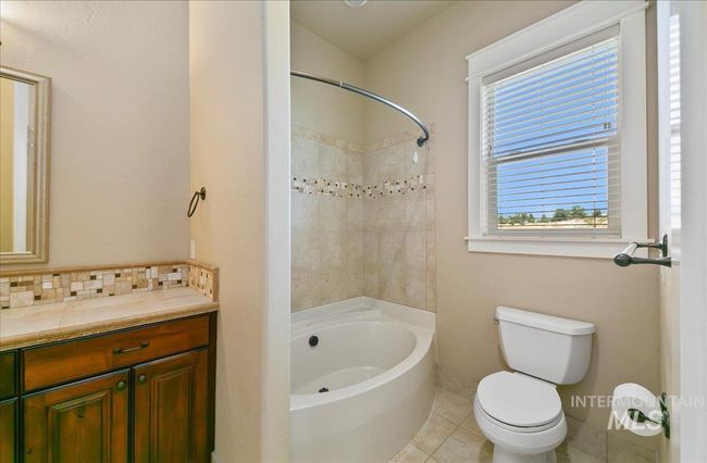 Full bath with vanity, decorative backsplash, tile patterned flooring, and shower / bath combination | Image 26