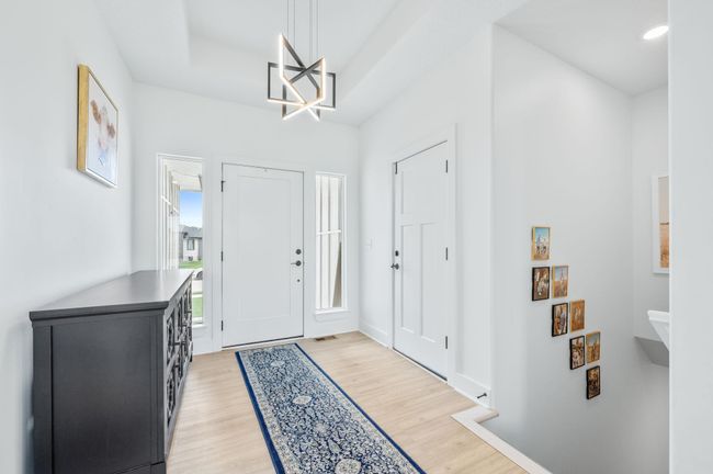 Foyer with light wood-style flooring, recessed lighting, a chandelier, and a tray ceiling | Image 5