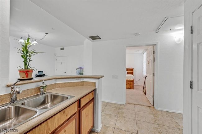 Kitchen featuring light tile patterned floors, light countertops, and brown cabinetry | Image 8