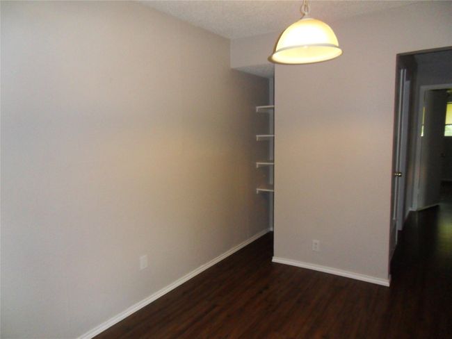 Empty room with dark wood-style flooring and baseboards | Image 5
