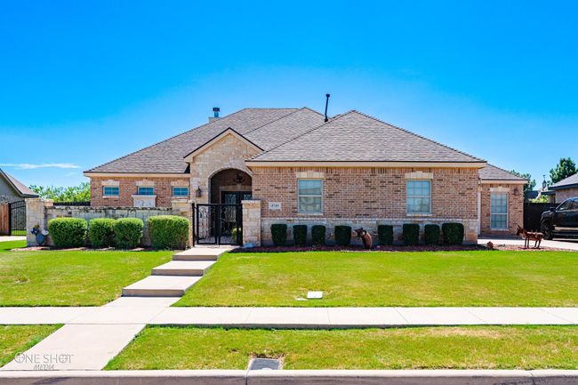 French provincial home featuring a gate, a shingled roof, brick siding, and stone siding | Image 40