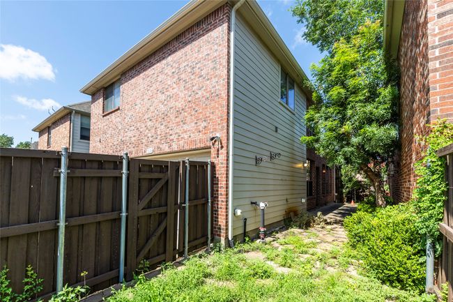 View of property exterior featuring a gate and brick siding | Image 31
