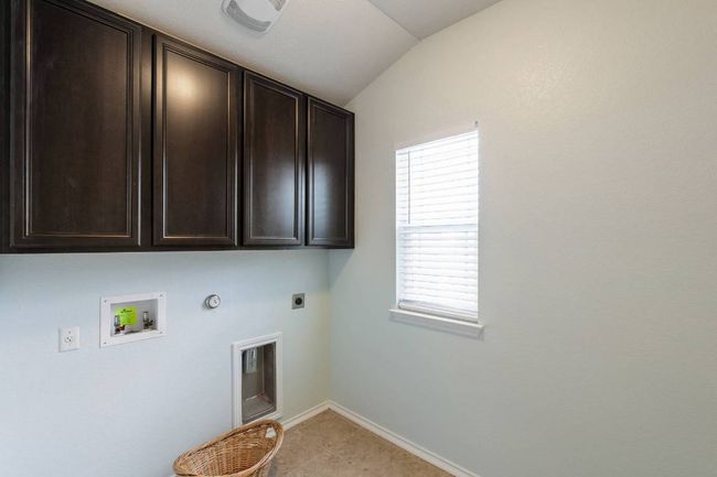Washroom featuring hookup for a gas dryer, electric dryer hookup, cabinet space, and hookup for a washing machine | Image 13