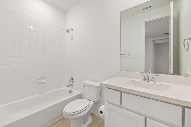 Full bath with vanity, toilet, tile patterned floors, visible vents, and shower / tub combination | Image 28