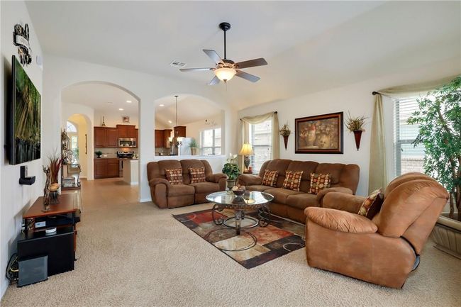 Living room featuring a ceiling fan, arched walkways, light colored carpet, plenty of natural light, and recessed lighting | Image 11