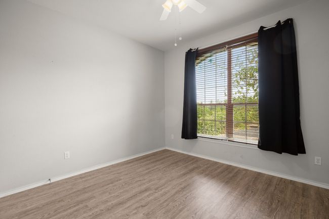 Unfurnished room featuring a ceiling fan, baseboards, and wood finished floors | Image 4
