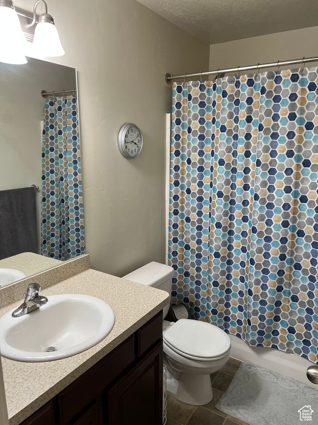 Bathroom with toilet, vanity, and a shower with shower curtain | Image 23