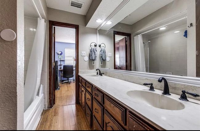 Bathroom featuring hardwood / wood-style floors, double vanity, and shower / tub combo with curtain | Image 11