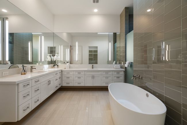 Bathroom with a freestanding bath, double vanity, tile walls, and recessed lighting | Image 19