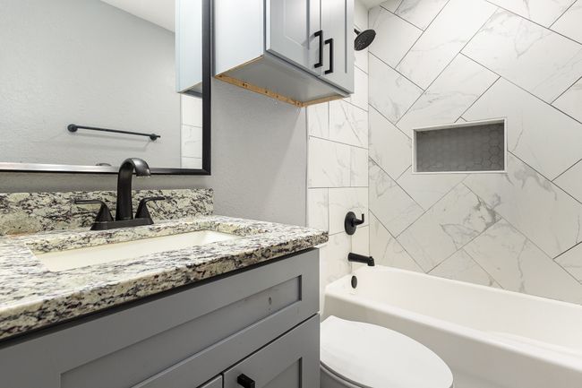 Full bathroom with vanity, toilet, and shower / washtub combination | Image 36