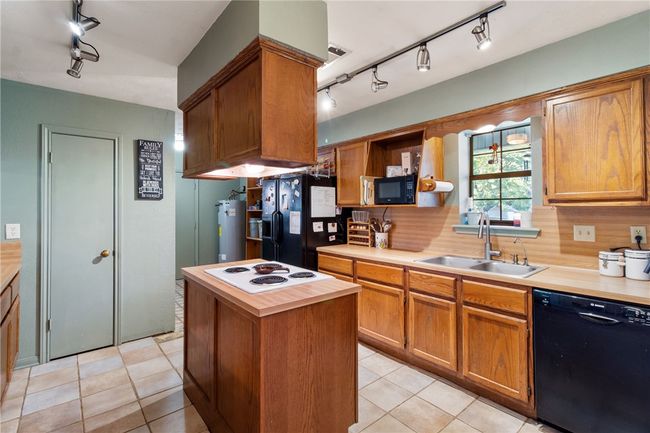 Kitchen featuring black appliances, track lighting, open shelves, backsplash, and light tile patterned floors | Image 8
