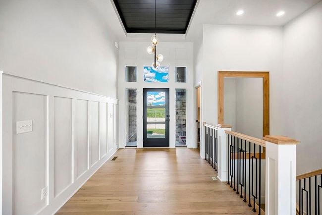 Entrance foyer with light wood finished floors, a decorative wall, and a high ceiling | Image 4