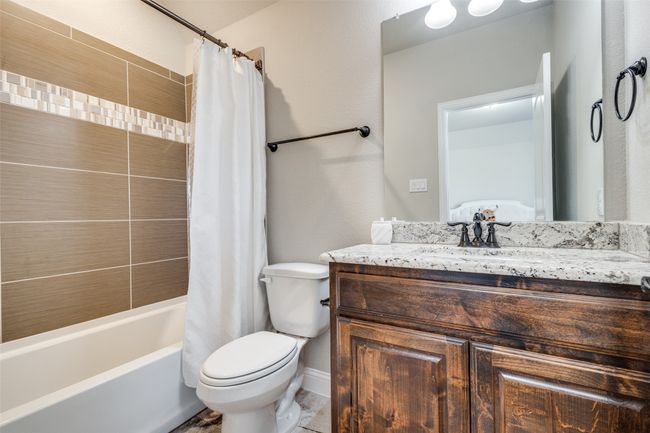 Full bathroom with vanity, toilet, and shower / bathtub combination with curtain | Image 31
