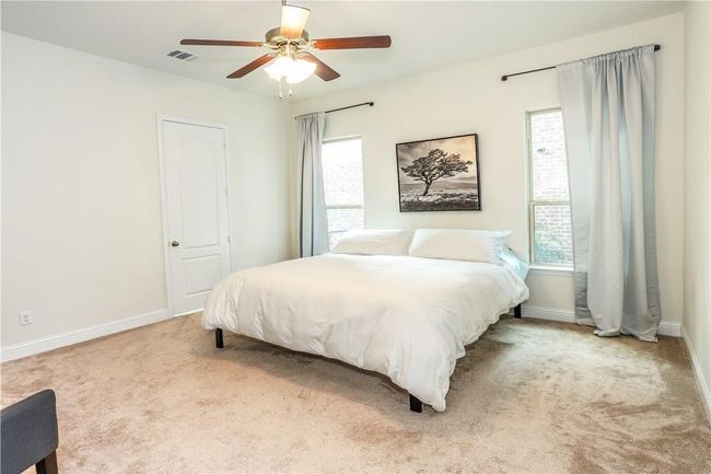 Carpeted bedroom with multiple windows and ceiling fan | Image 15