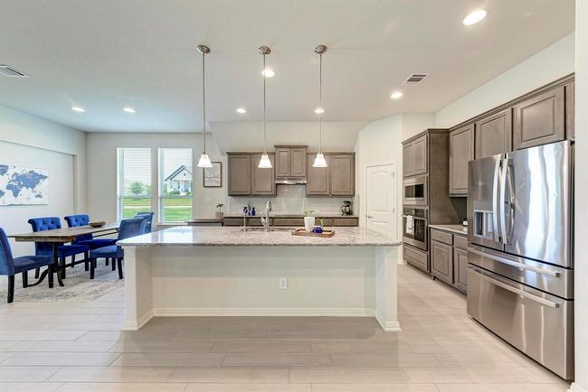 The eat-on island, granite countertops, abundant cabinetry (42-inch), and pantry closet are just a few "ingredients" that complete this gourmet kitchen. | Image 10