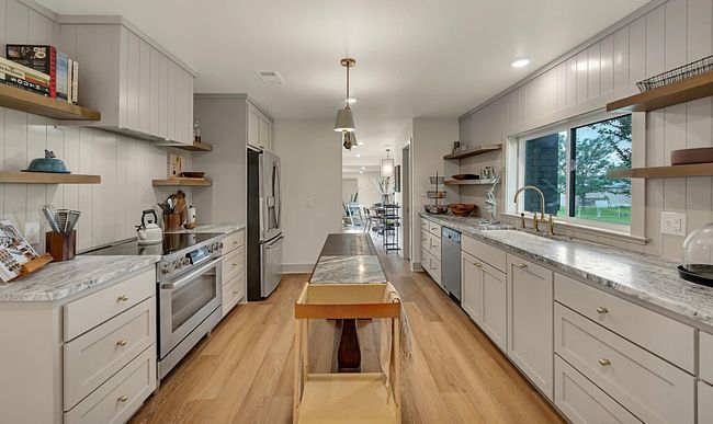 Kitchen featuring open shelves, stainless steel appliances, light wood finished floors, hanging light fixtures, and recessed lighting | Image 12