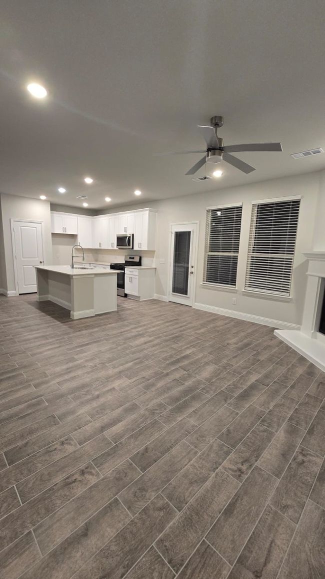 Unfurnished living room featuring dark wood-type flooring, a sink, recessed lighting, baseboards, and a ceiling fan | Image 14