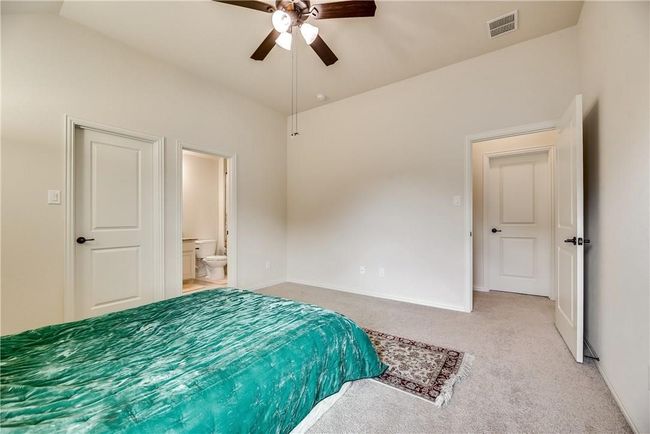 Bedroom featuring light carpet, baseboards, ensuite bath, and ceiling fan | Image 20