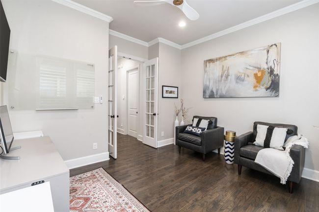 This spacious home office features french door glass entry, upgraded ceiling fan & hand scraped hardwoods | Image 7