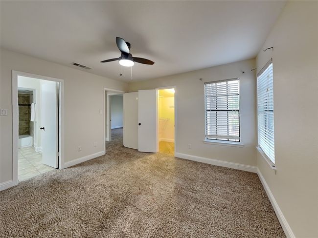 Unfurnished bedroom featuring light colored carpet, a spacious closet, baseboards, and visible vents | Image 17
