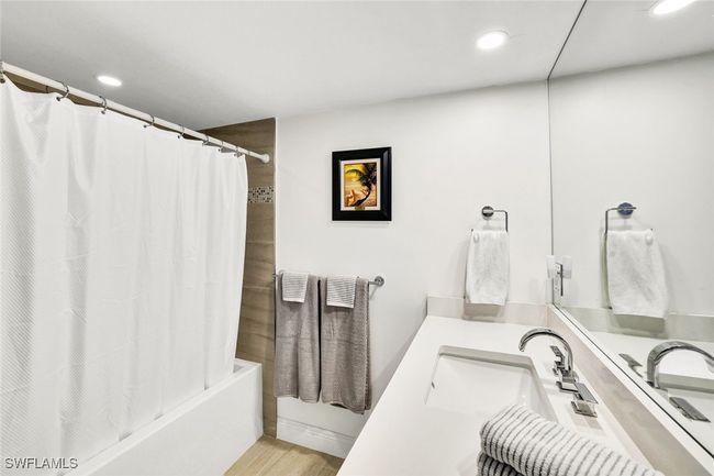 Bathroom featuring recessed lighting, wood finished floors, vanity, and shower / bathtub combination with curtain | Image 25