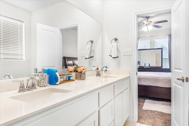 Ensuite bathroom featuring ceiling fan, double vanity, a sink, and connected bathroom | Image 18