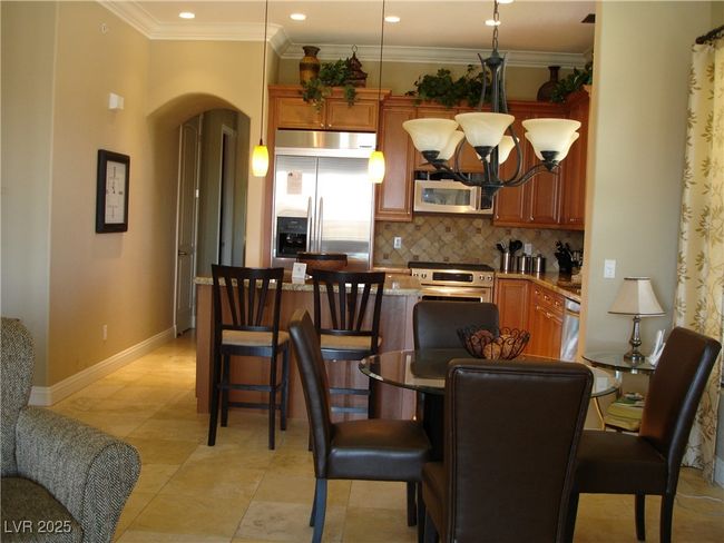 Dining area featuring arched walkways, a chandelier, recessed lighting, and ornamental molding | Image 7