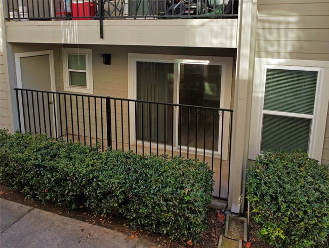 View of covered and fenced patio with a sliding door and extra storage | Image 36