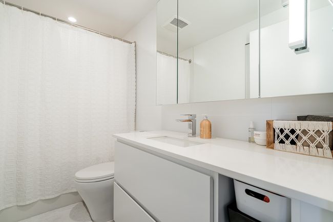 Bathroom featuring visible vents, toilet, vanity, and a shower with shower curtain | Image 25