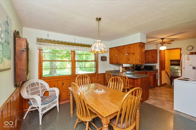 dining space featuring a wainscoted wall, ceiling fan, and a textured ceiling | Image 9