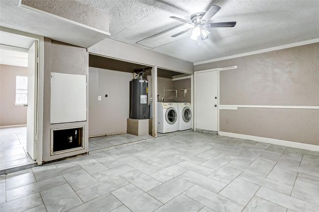 A unique perspective reveals the bonus room’s built-in laundry area with modern washer and dryer hookups. The adjacent space can be tailored to your needs, whether as a family room or hobby area. The neutral flooring ties the room together with style and practicality. | Image 21