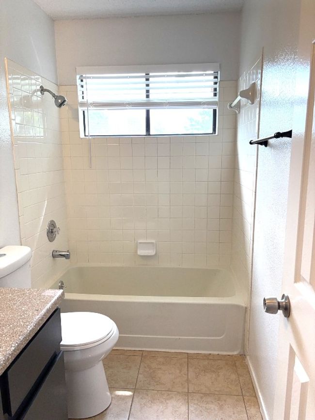 Bathroom with vanity, shower / bathtub combination, and tile patterned flooring | Image 13