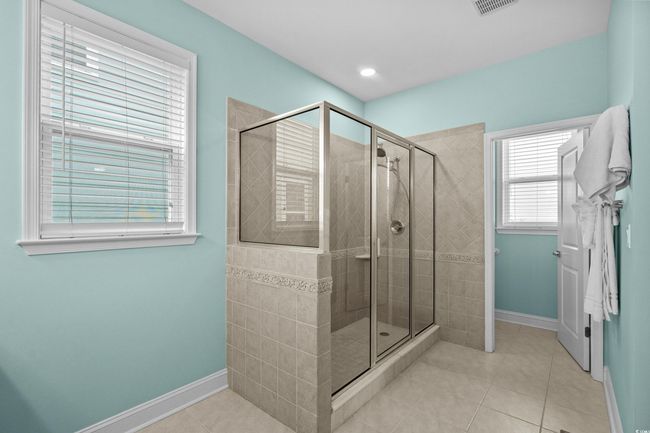 Bathroom with baseboards, a shower stall, and tile patterned flooring | Image 15