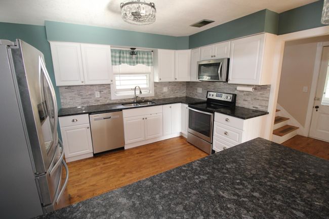 Bright kitchen with stainless Steel appliances and stone counter tops | Image 14