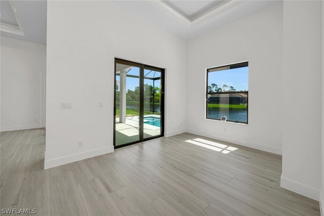10'-10" x 12'-2" Dining room featuring 13' tray ceiling, Lanai slider with a beautiful pool and water fountain lake view. | Image 8