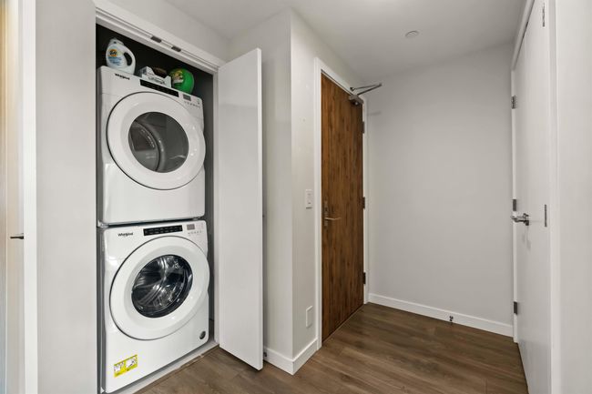 Laundry room with stacked washer / dryer, baseboards, laundry area, and dark wood-type flooring | Image 20