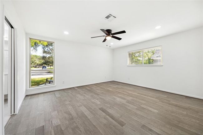 The primary bedroom has been expanded into a luxurious retreat for homeowners, filled with abundant natural light. | Image 10